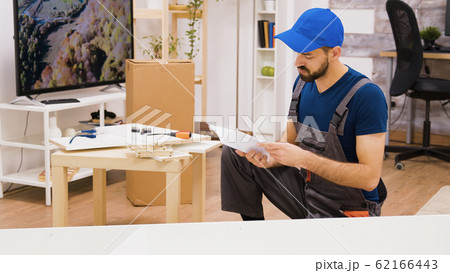 Professional furniture assembly worker checking position of the shelf Professional furniture assembly worker checking position of the shelf 62166443