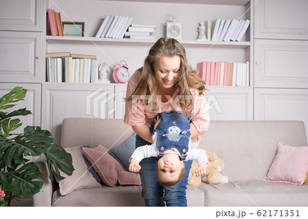 Mother holds happy baby upside down in the 62171351