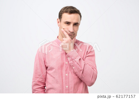 Pensive caucasian young man thinking or considering idea, trying to make a right choice. 62177157