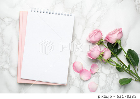 Beautiful pink roses flower and notebook on marble background.Minimalistic composition for the holidays,valentines day and womens day. 62178235