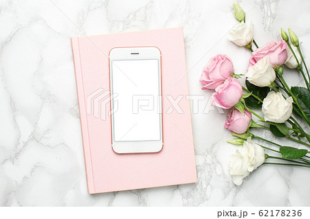 Mobile phone with pink and white roses flowers on marble background.Minimalistic composition for the holidays,valentines day and womens day. 62178236