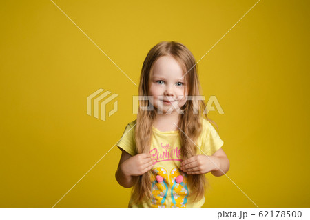 Adorable caucasian kid with long hair smiling at 62178500