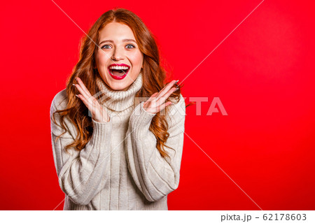 Portrait of girl with red hair, she shows wow delight effect gesture. Copy space. Surprised excited happy woman. Pretty female shocked model on studio background. 62178603
