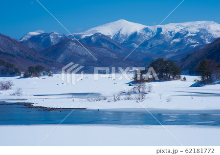 真冬に凍結した裏磐梯秋元湖の雪景色とワカサギ釣りの写真素材