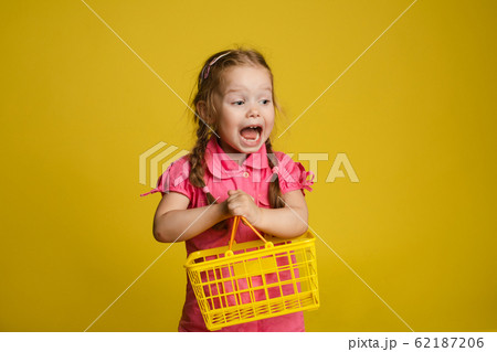 Funny little girl with shopping basket. Isolate on Funny little girl with shopping basket. Isolate on 62187206