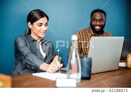 Cheerful international office worker looking at his friend Cheerful international office worker looking at his friend 62188873