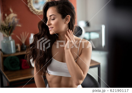 Gorgeous young woman with perfect skin touching neck 62190117