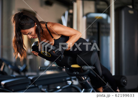 Sportswoman doing hyperextension exercise. 62199633