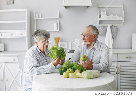 Beautiful old couple prepare food in a kitchen Beautiful old couple prepare food in a kitchen 62201672