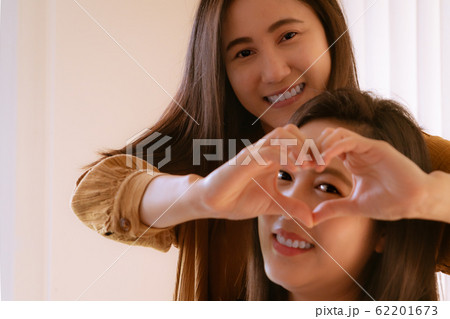 Happy Woman Day. two beautiful  Woman friends Holding Heart Shaped Hands. Healthy Eyes And Vision. 62201673