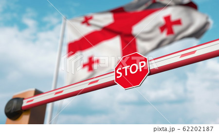 Closed boom barrier with stop sign against the Georgian flag. Restricted entry or certain ban in Georgia. 3D rendering 62202187