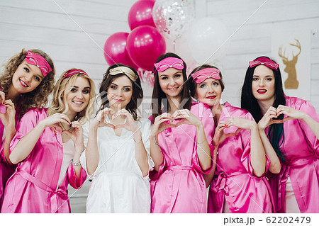Lovely bridesmaids in pink robes and sleep masks Lovely bridesmaids in pink robes and sleep masks 62202479