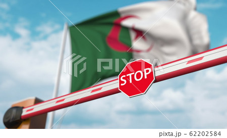 Barrier gate being closed with flag of Algeria as a background. Algerian restricted entry or certain ban. 3D rendering 62202584