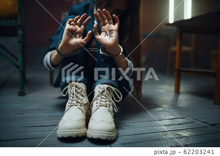 Handcuffed female victim of maniac kidnapper 62203241