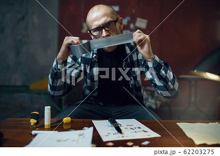 Maniac kidnapper prepares adhesive tape Maniac kidnapper prepares adhesive tape 62203275