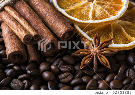 Cinnamon sticks, dried orange and star anise on a roasted coffee beans background. 62203885