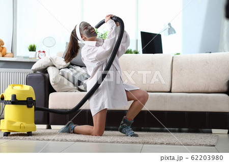 Funny dancing at home while cleaning living room. 62203980