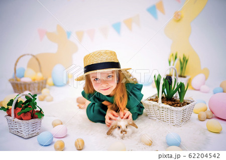 the girl with the rabbit. happy little girl holding cute fluffy Bunny. Friendship with Easter Bunny. Spring photo with beautiful young girl with her Bunny. Girl is holding a cute little rabbit 62204542
