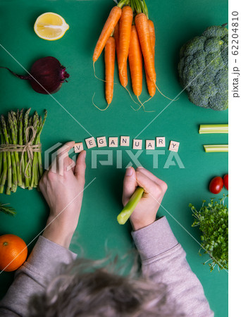 Top view male hands laying word Veganuary on green 62204810