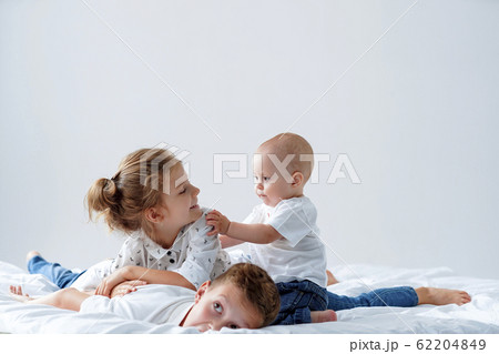 Brother And Sister Relaxing Together In Bed 62204849