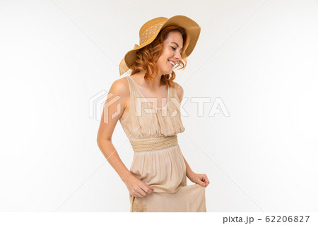 portrait of a cute happy charming beautiful blond girl in a dress and a straw hat on a white 62206827