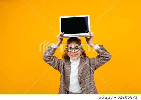 funny beautiful girl in a classic jacket holds a laptop above her head with a mock up display funny beautiful girl in a classic jacket holds a laptop above her head with a mock up display 62206873