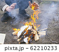 man warms himself by the fire, camping bonfire 62210233