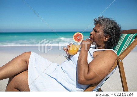 Old woman relaxing at the beach 62211534