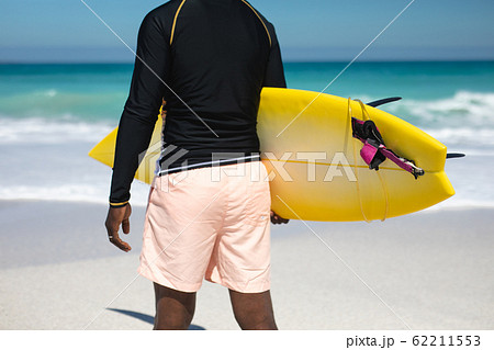 Old man carrying a surfboard Old man carrying a surfboard 62211553