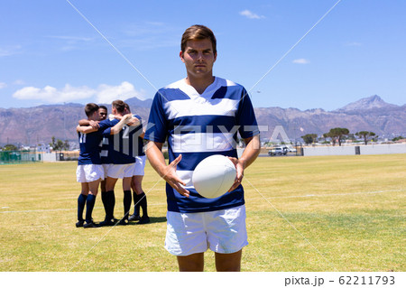 Rugbymen standing with ball 62211793