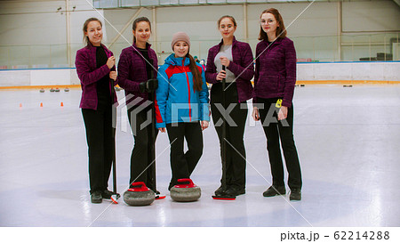 Curling training - the judge standing on the ice rink with her students 62214288