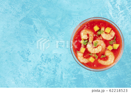 Coctel de camarones, Mexican shrimp cocktail with avocado, a top-down shot on a blue background with a place for text 62218523
