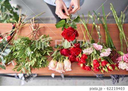 Floral shop concept . Florist woman creates flower arrangement. Beautiful bouquet of mixed flowers. Handsome fresh bunch. Flowers delivery 62219403