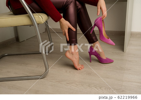 Woman suffering from leg pain in office. 62219966