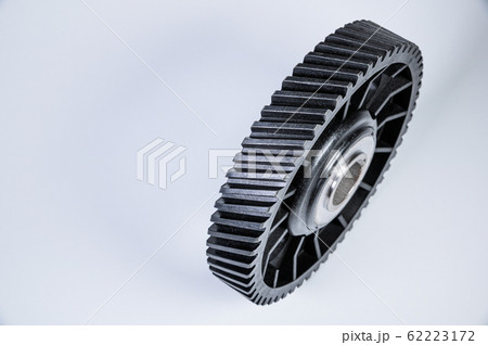 Black polymer gear camshaft with metal base. New spare part for an internal combustion engine on a gray background Black polymer gear camshaft with metal base. New spare part for an internal combustion engine on a gray background 62223172