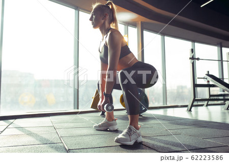The female athlete training hard in the gym. Fitness and healthy life concept. The female athlete training hard in the gym. Fitness and healthy life concept. 62223586