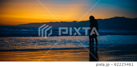 silhouette of couples in love on the beach at sunrise silhouette of couples in love on the beach at sunrise 62225461