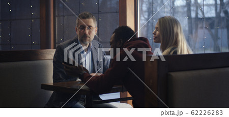 Young man showing smartphone to businessman 62226283