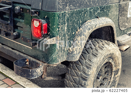 Close-up detail mud dirty wheel of off-road lifted awd ATV SUV car after extreme rally cross competition. Tuned all-terreain-vehicle part outdoor swamp countryside trophy challenge. Adventure concept 62227405