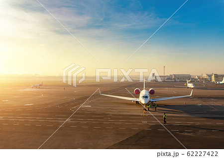 Colorful scenic dramatic morning sunset at airport asphalt taxiway and parking with different commercial passenger airplanes and private jets ready dor departure. Flight tickets booking and charter 62227422