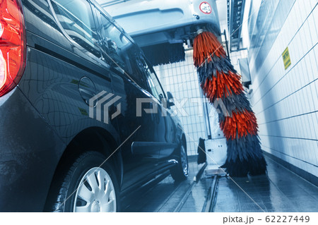 automatic tunnel car wash machine. Grey and red soft brushes washing vehicle with foam at gas petrol service cleaner station. Carwash business automatic tunnel car wash machine. Grey and red soft brushes washing vehicle with foam at gas petrol service cleaner station. Carwash business 62227449