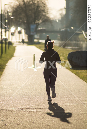 Portrait on back view of girl running in border river bu sunset 62227574