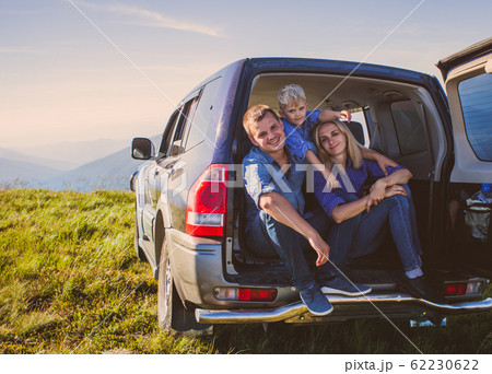 Young family travelling by car in mountains during summer vacation 62230622