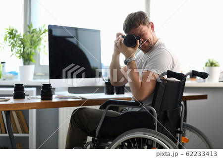 Male disabled photographer holds camera in his hands 62233413