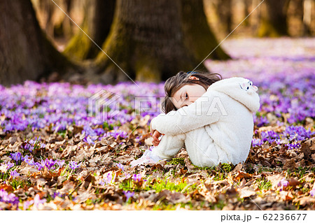 Lonely girl sitting on a ground in spring forest 62236677