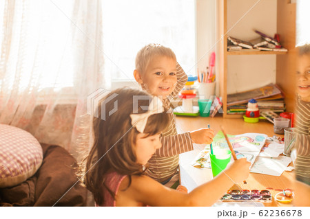 Cute kids painting with paintbrush and colorful paints 62236678