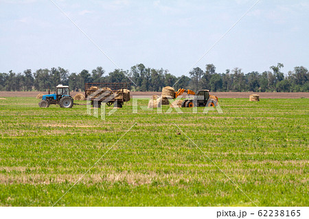 Tractor loading hay bales on truck agricultural works Tractor loading hay bales on truck agricultural works 62238165