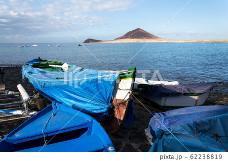 Traditional wooden fishing boats in El Medano harbour with Montana Roja in background, Tenerife, Canary Islands, Spain, sunrise on sunny summer day 62238819
