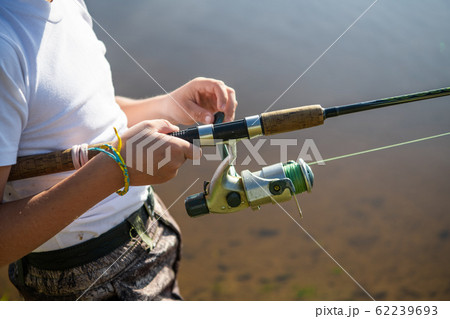 Close-up photo of a young boy fishing outdoors on a summer day. 62239693