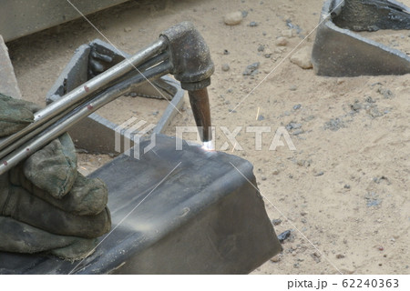 Workers at construction site cutting metal using blowtorch. Blowtorch produced very high temperature flame that able to cut metal in short time.  62240363